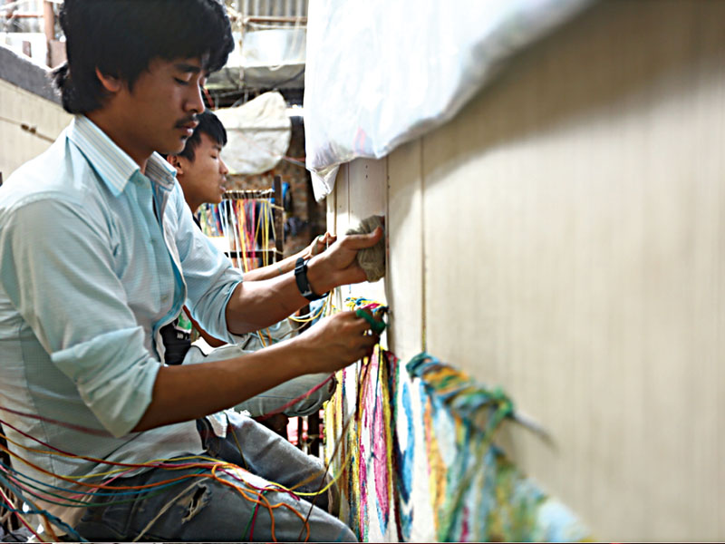 Nepali weavers knotting Creative Matter’s Dream Vibrant carpet.